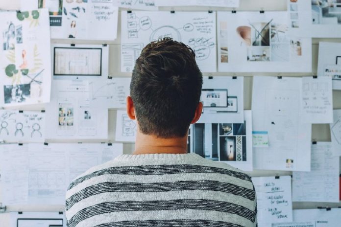office worker looking at full white board