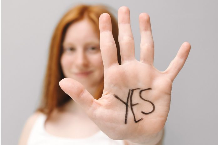 woman holding up hand saying yes