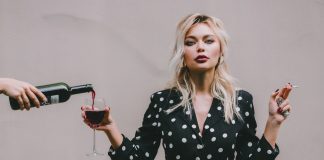 woman in spotted dress with cigarette and wine