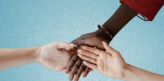 Intertwined hands of people of different color and race