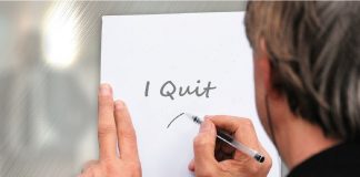 man writing note on paper