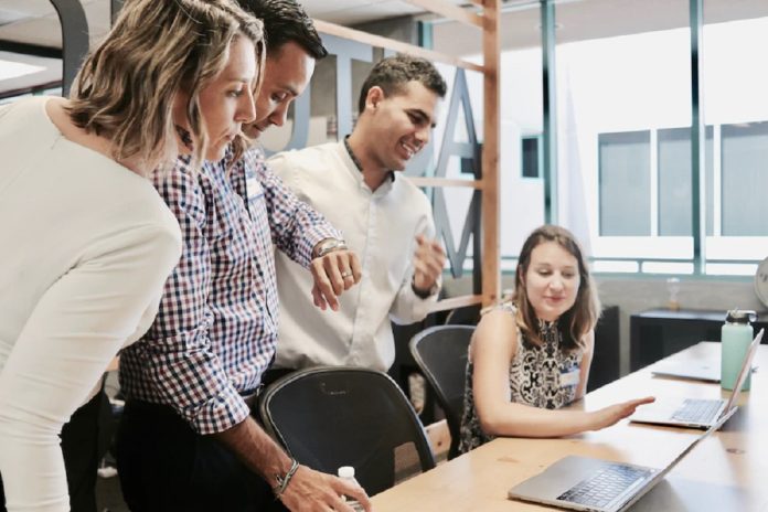 group of office workers discussing new software
