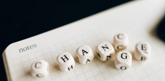 "change" spelled out in scrabble type tiles in top of a notepad