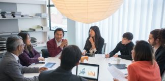 group in deep discussion around round conference table